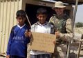 A US soldier demonstrating the military's trademark sensitivity for delicate cultural situations to some Iraqi children.